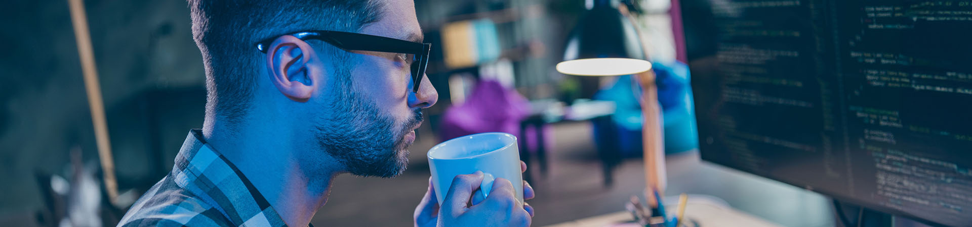 A male programmer at his workstation uses Altair AI Cloud software to build and deploy complex machine learning algorithms in a full cloud-based environment.