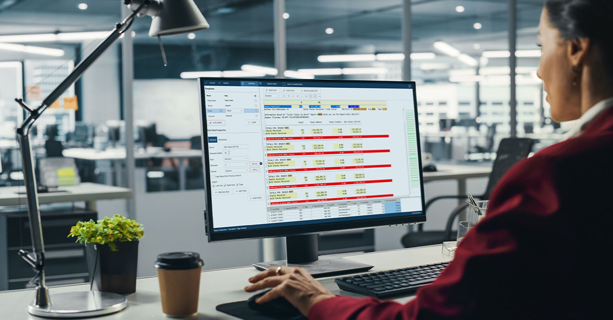 A woman works on a computer, preparing data analytics and reviewing a PDF report.